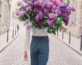 A young woman carries a glorious giant bouquet of lilacs in “On My Way,” from the Young Girl in Bloom series | Photo By Carla Coulson