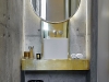 The vanity in the guest bathroom is a prime example of the way in which Enrico Daffonchio and Frances Joynt have layered and contrasted raw materials. “When you have a mirror and brass over the raw concrete, there’s such a strong tension between the materials,” says Daffonchio