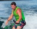 Joshua Cook, a partially sighted Watersports Program Specialist at CNIB Lake Joe tries surfing with the Pride Marine G23 Paragon ski boat at CNIB Lake Joe Dock-to-Dock: Taste of Muskoka event (photo: Maya Burgess)
