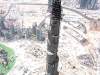 The Burj Dubai – supported by its flower-like base – makes neighbouring 50-storey buildings look like bits of debris, scattered along a seemingly barren landscape.
