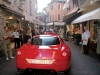 A Ferrari 599 GTB Fiorano zips through a narrow street near Lake Maggiore.