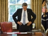 President Barack Obama reads a document during a break between phone calls in the Oval Office, Oct. 13, 2009.