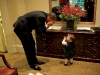 President Barack Obama plays with the daughter of Emmett Beliveau, the director of advance, in the Outer Oval Office, Oct. 30, 2009.