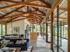 Tehama 2: The interior concrete flooring extends to the exterior porch, while the ceiling is paneled in reclaimed barn-wood siding and the asymmetrical trusses are Douglas fir. The result is a low-maintenance home that doesn't require the need for air conditioning | Photo credit: Tim Griffith Photography
